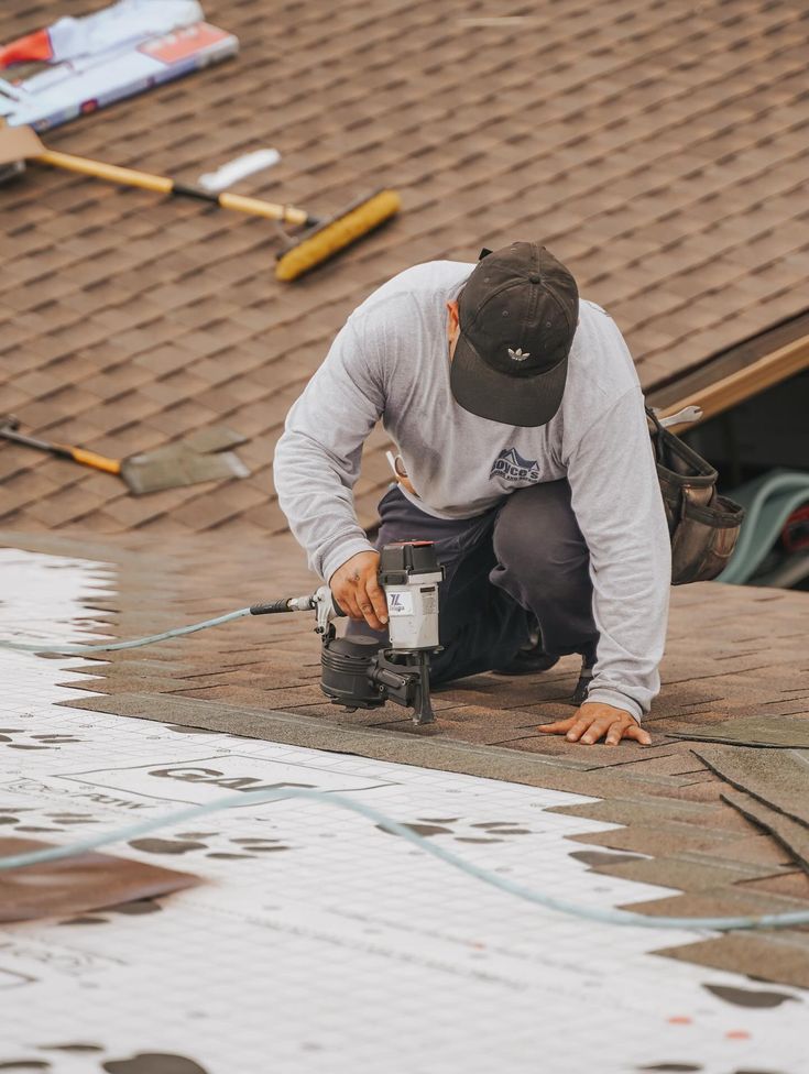Roofer nailing down underlayment